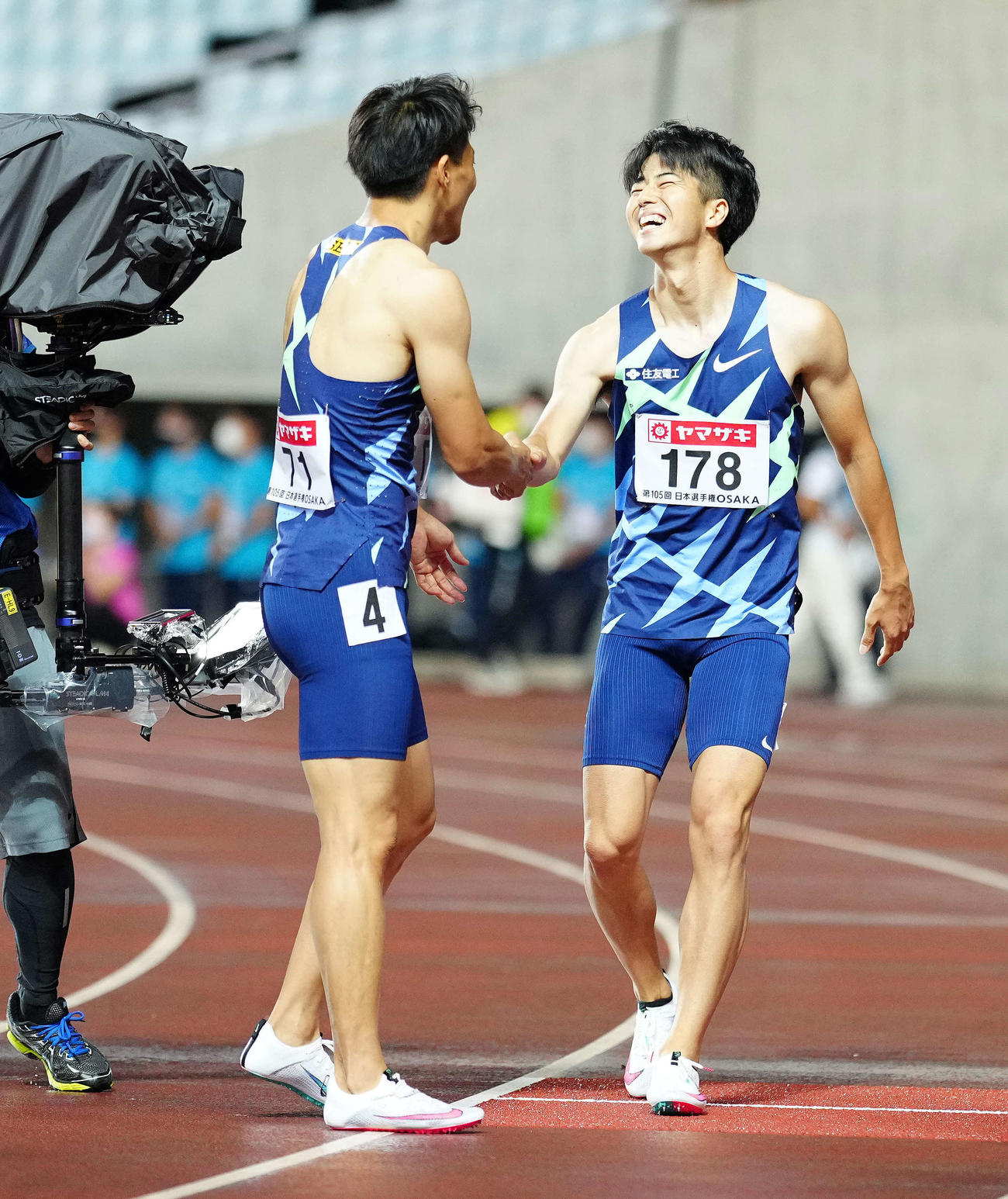 男子100メートルで優勝し3位の山県（左）と握手をかわす多田（撮影・江口和貴）