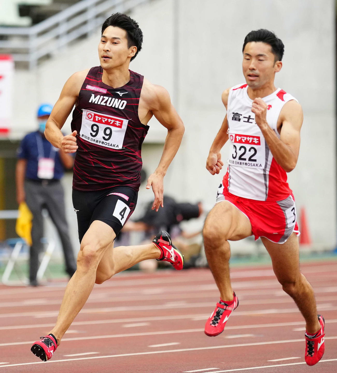 男子200メートル予選2組で1着の飯塚（左）。右は5着の橋元（撮影・江口和貴）