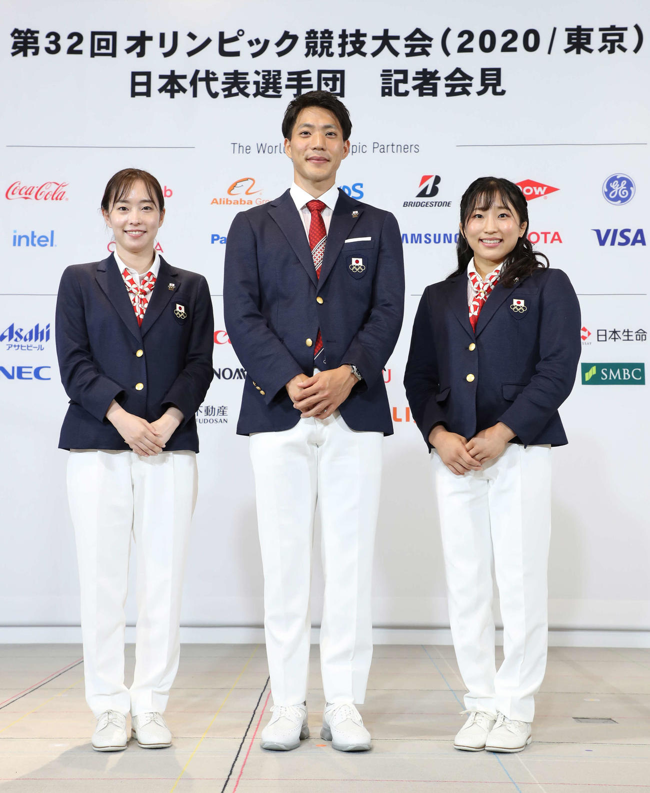 記者会見を終え、記念撮影に臨む東京五輪日本代表選手団の、左から副主将の石川、主将の山県、旗手を務める須崎（代表撮影）