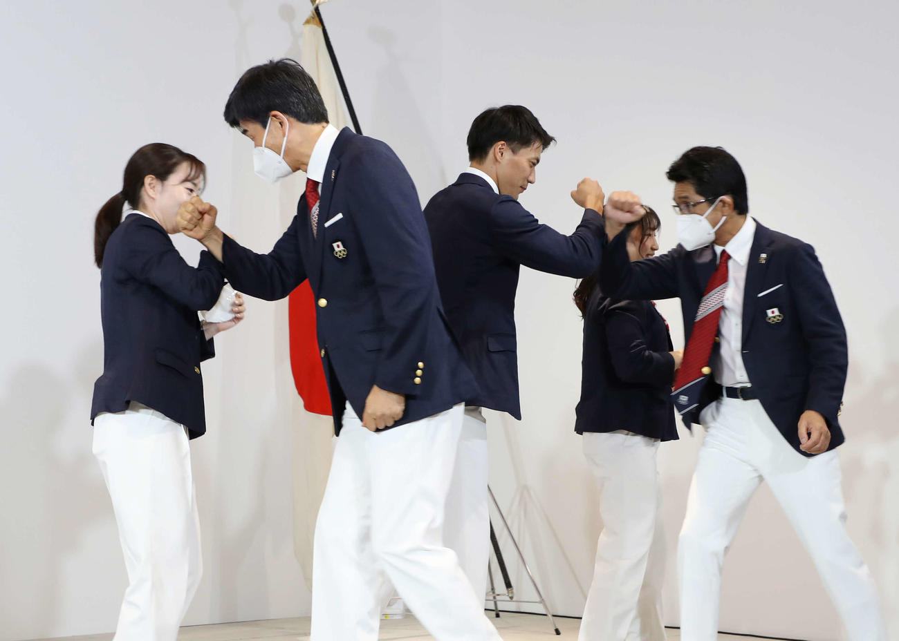 記者会見を終え、肘でタッチして引き揚げる東京五輪日本代表選手団の主将の山県（中央）ら（代表撮影）