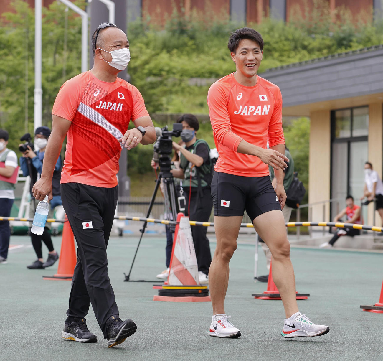 笑顔を見せる山県亮太（右）。左は土江寛裕オリンピック強化コーチ（代表撮影）
