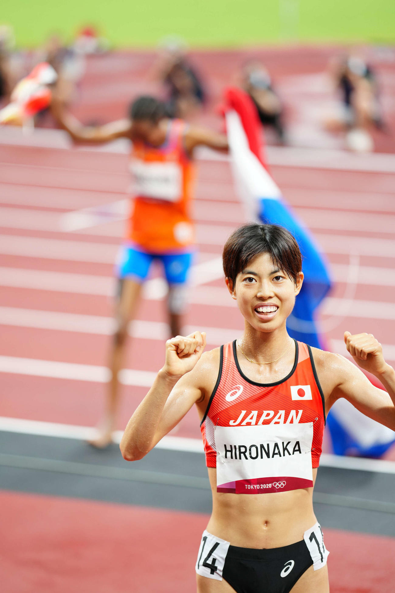 女子5000メートル決勝で9位の広中は日本新記録を樹立しガッツポーズを見せる。後方は優勝したハッサン（撮影・江口和貴）