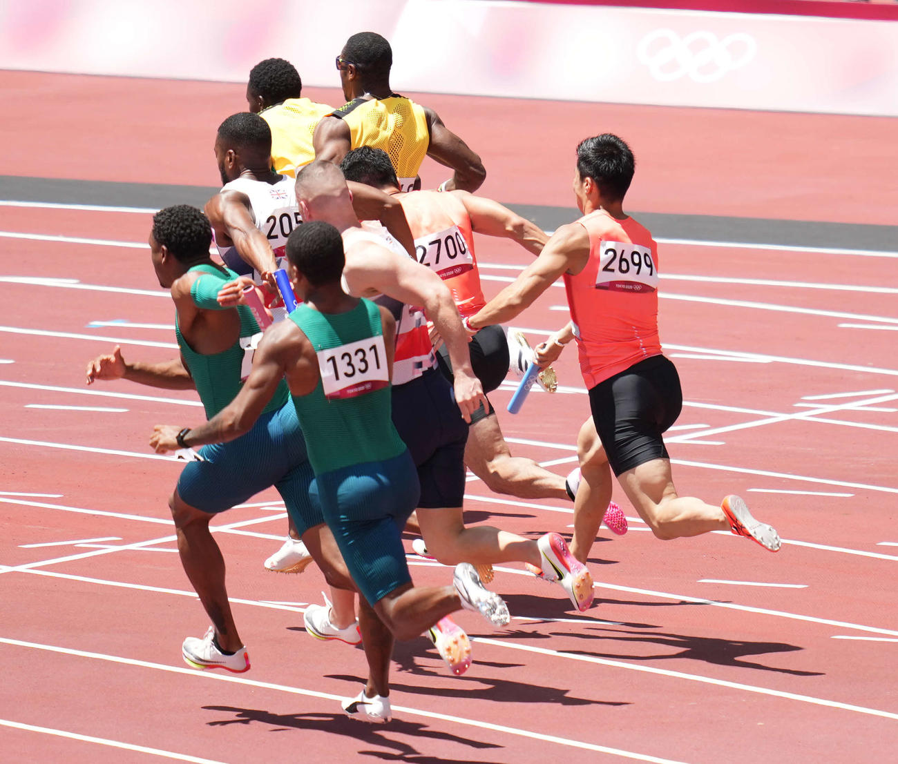 男子400メートルリレー予選　アンカーの小池（中央左）にバトンパスする第3走者の桐生（同右）（撮影・鈴木みどり）