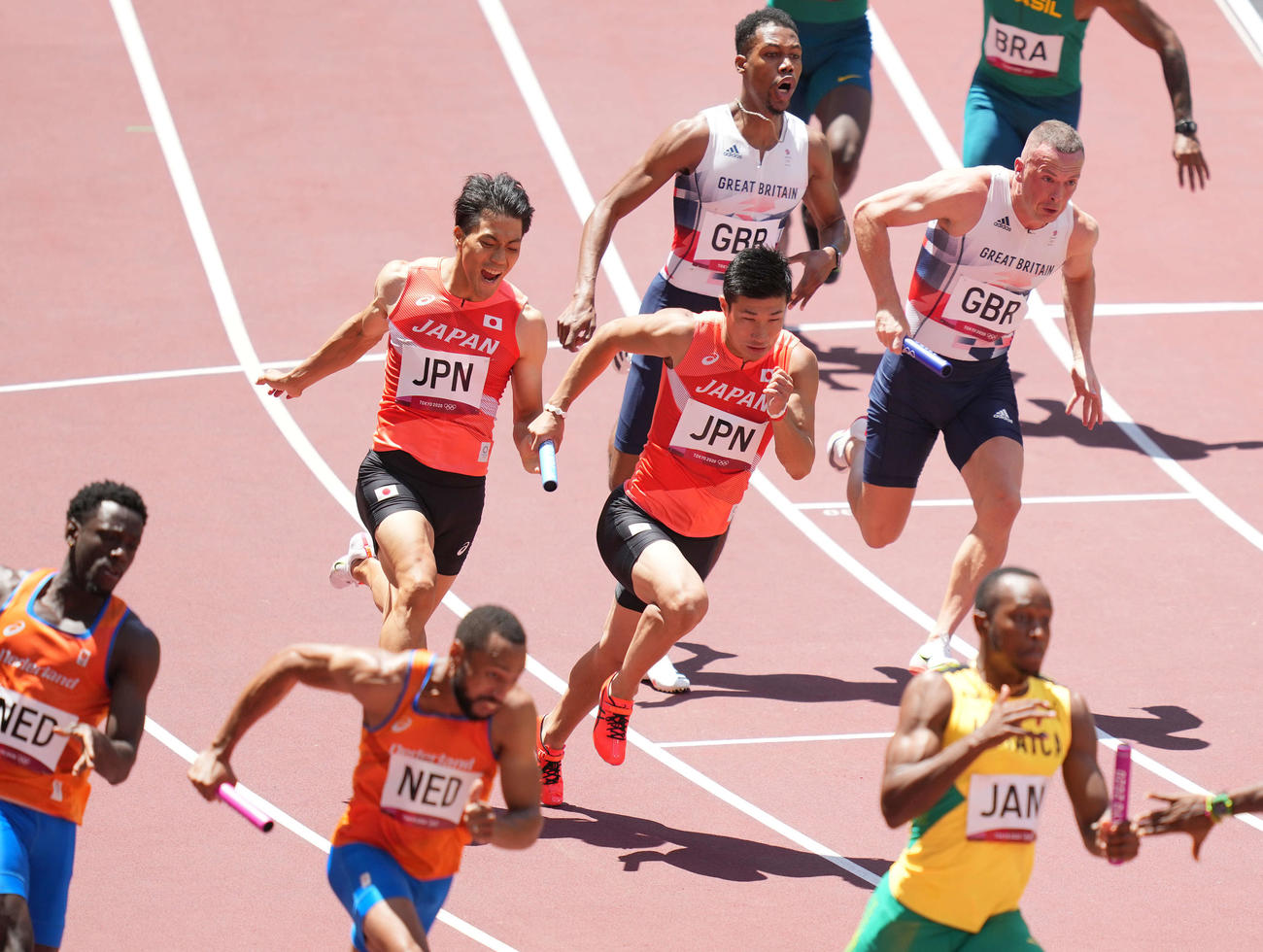 男子400メートルリレー予選　第3走者の桐生（中央右）にバトンパスする第2走者の山県（同左）（撮影・鈴木みどり）