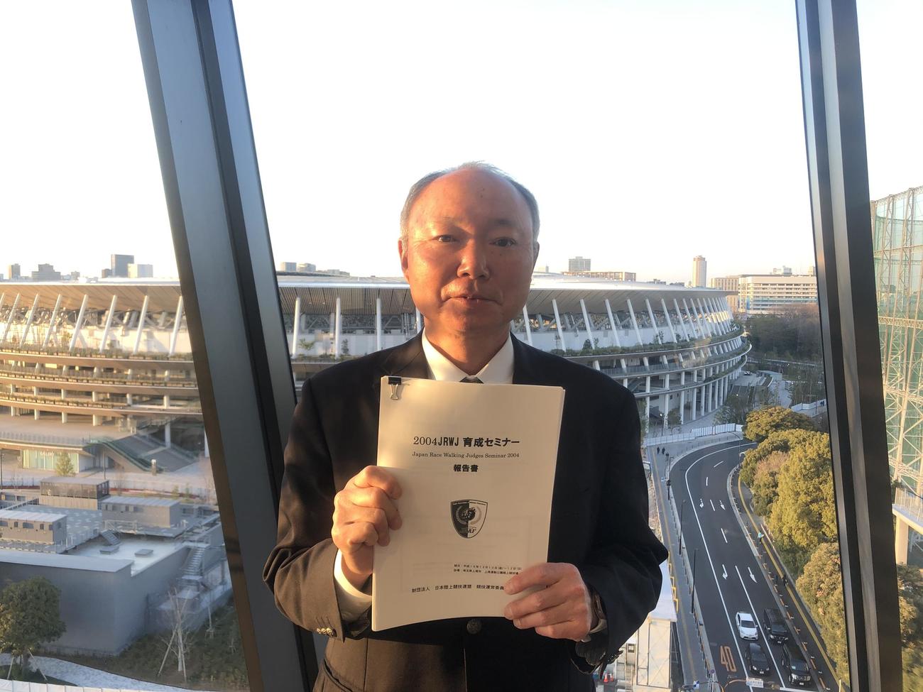 競歩の審判員育成セミナーの資料を手にし、笑顔を見せる藤崎明さん（撮影・上田悠太）