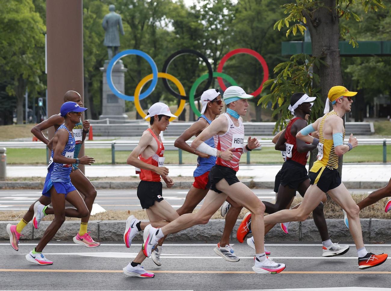 レース序盤、五輪マークのモニュメント前を力走する中村匠吾（中央左）（共同）