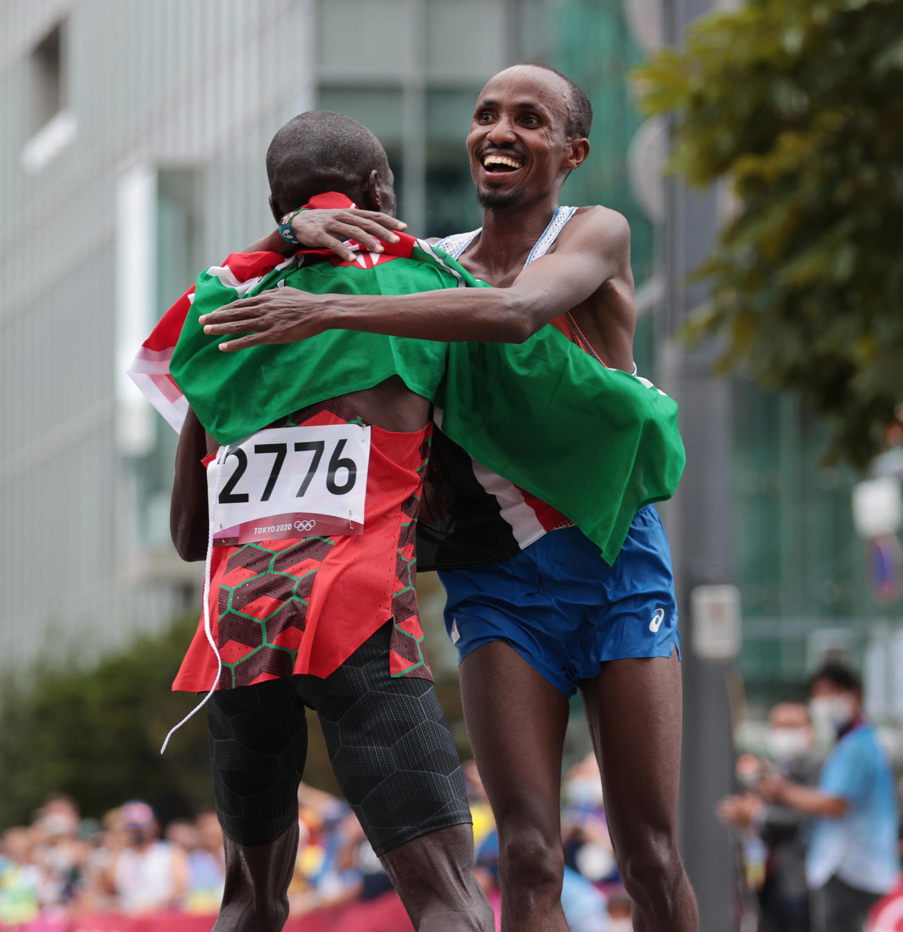 陸上男子マラソン　優勝したケニアのキプチョゲ（左）と抱き合って喜ぶ2位のオランダのナゲーエ（代表撮影）