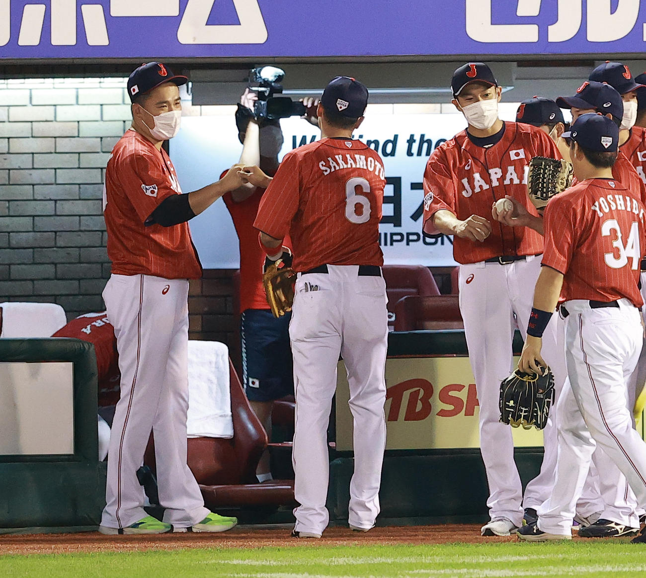 巨人対日本代表　8回裏巨人の攻撃を抑えた坂本（中央）ら野手陣をグータッチで迎える田中将（左）、柳田（右）ら（撮影・浅見桂子）