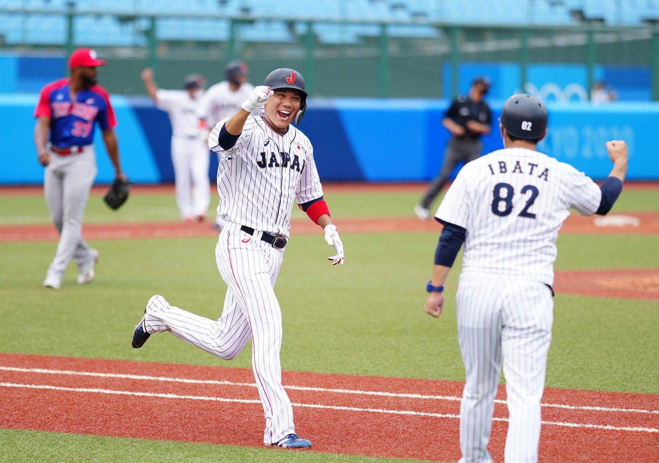 日本対ドミニカ共和国　9回裏日本1死満塁、サヨナラ打を放ち、笑顔でガッツポーズの坂本。右は井端一塁ベースコーチ（撮影・江口和貴）