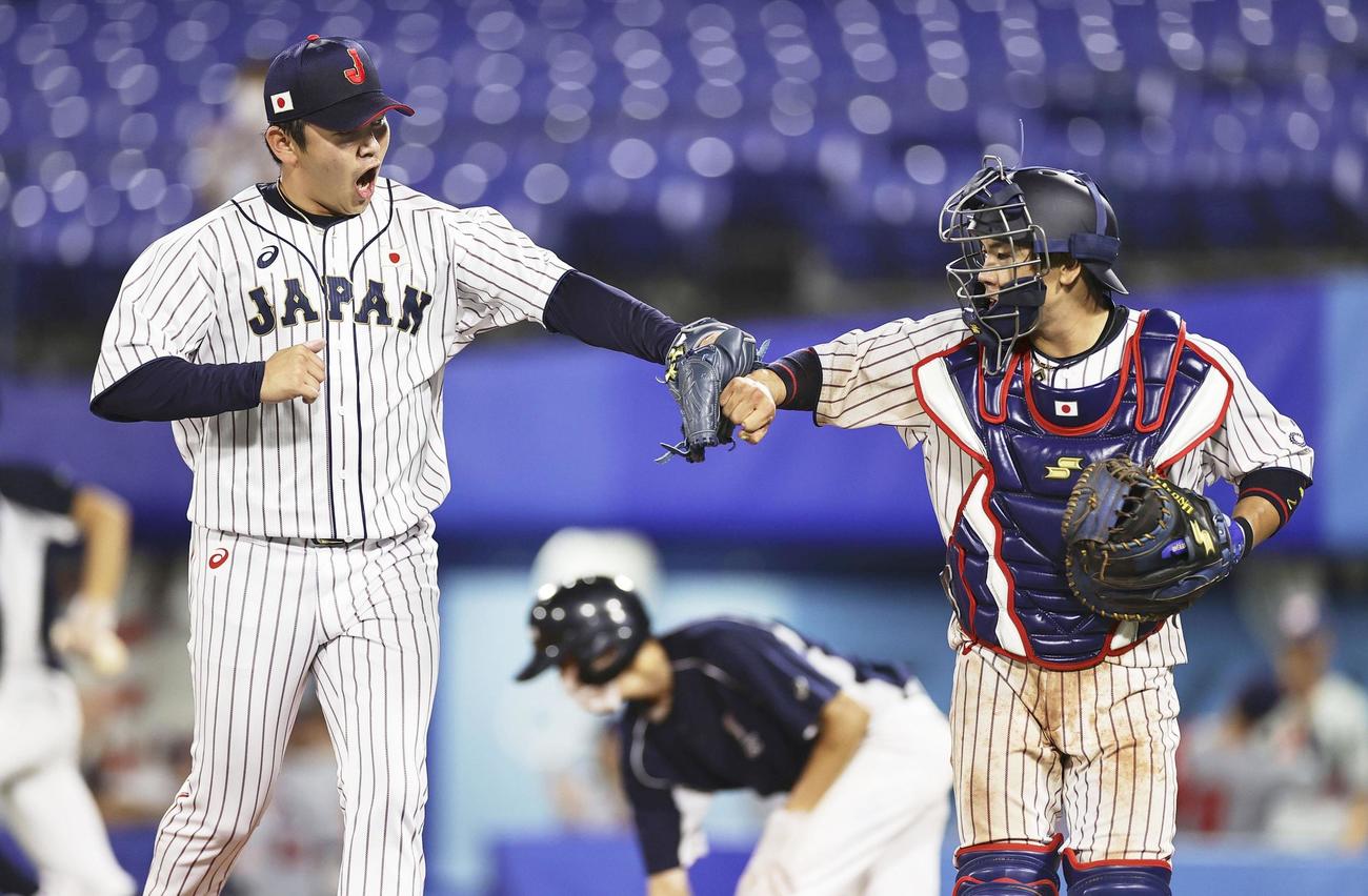 8回、無失点で終え、捕手梅野とタッチを交わす山崎（共同）
