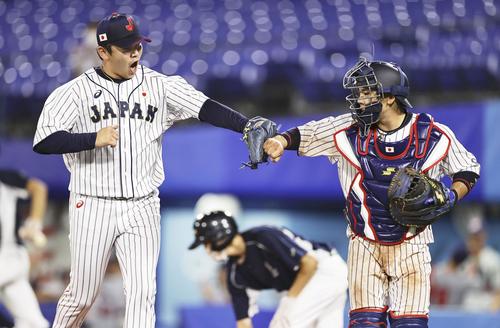 8回、無失点で終え、捕手梅野とタッチを交わす山崎（共同）