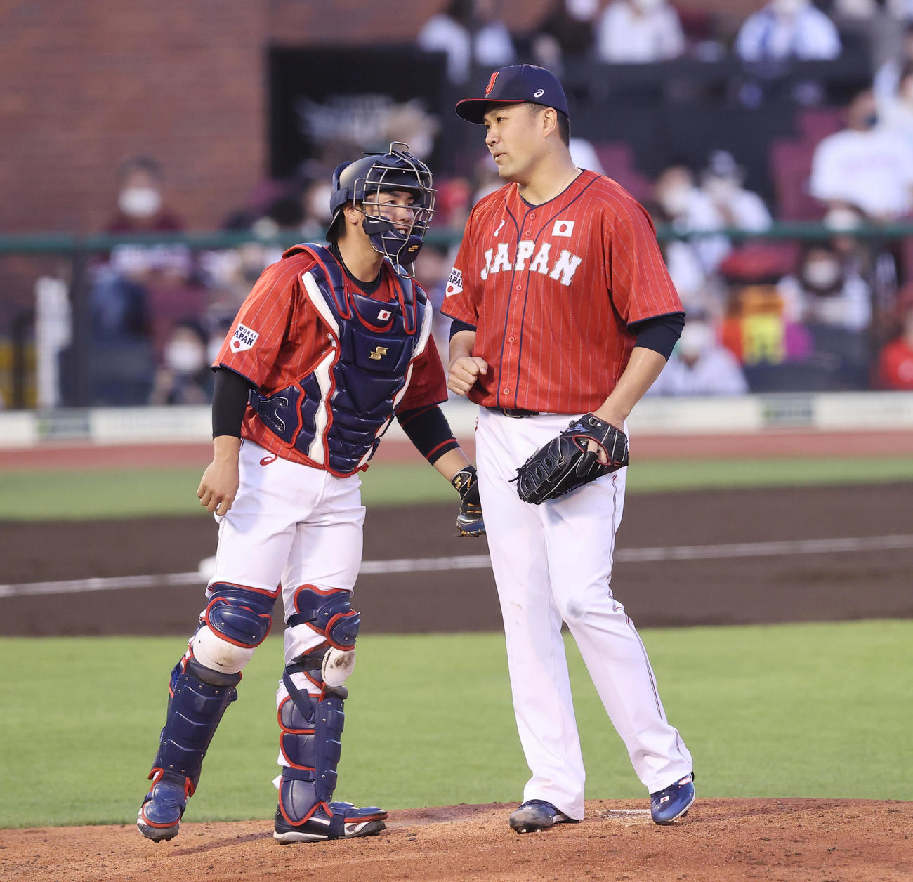 7月25日、巨人との強化試合で降板する田中将（右）と笑顔で言葉を交わす梅野