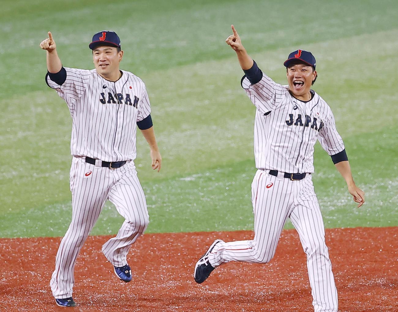 優勝を決め、笑顔でナインに駆け寄る田中将（左）と大野（共同）