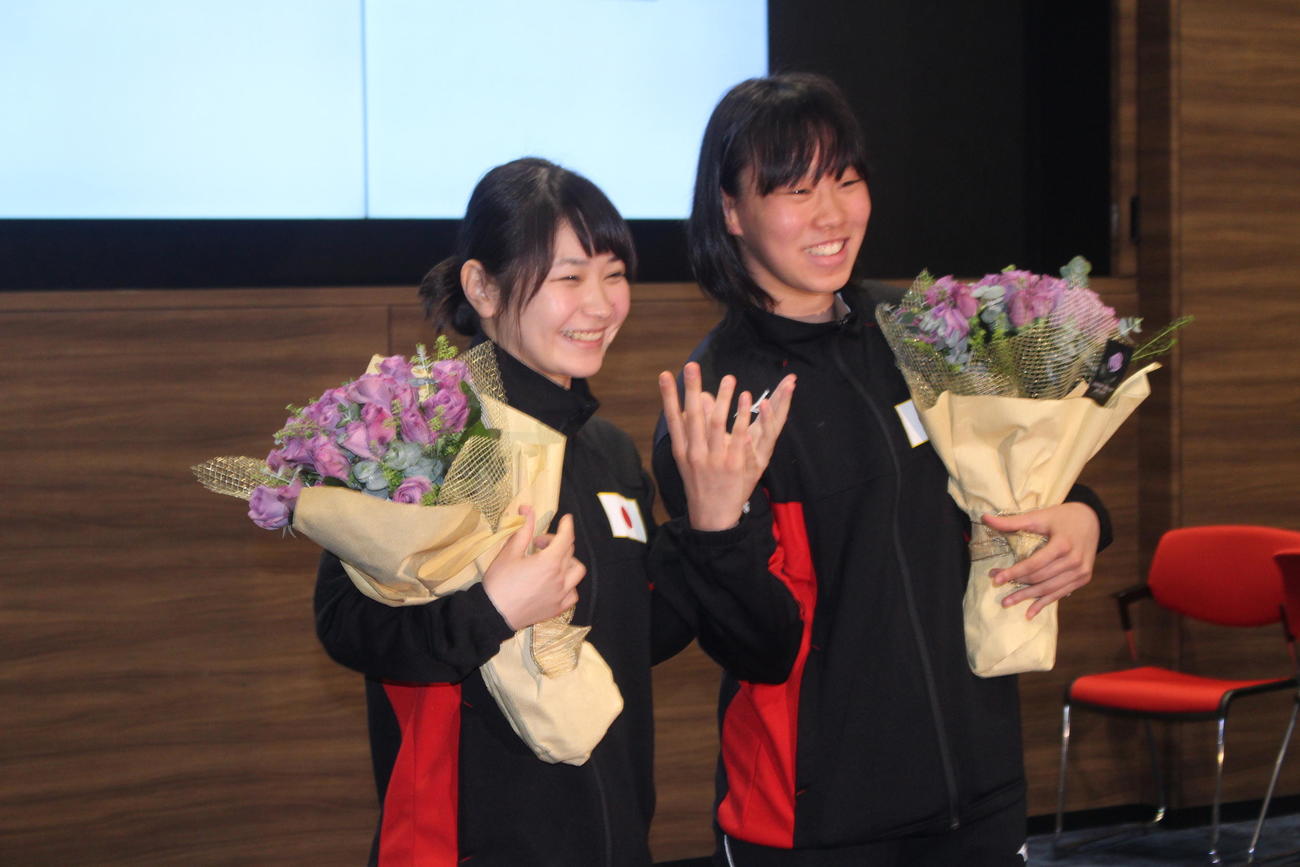 青い薔薇を手にする女子日本代表「ブルーローズ・ジャパン」の並木（左）と入江