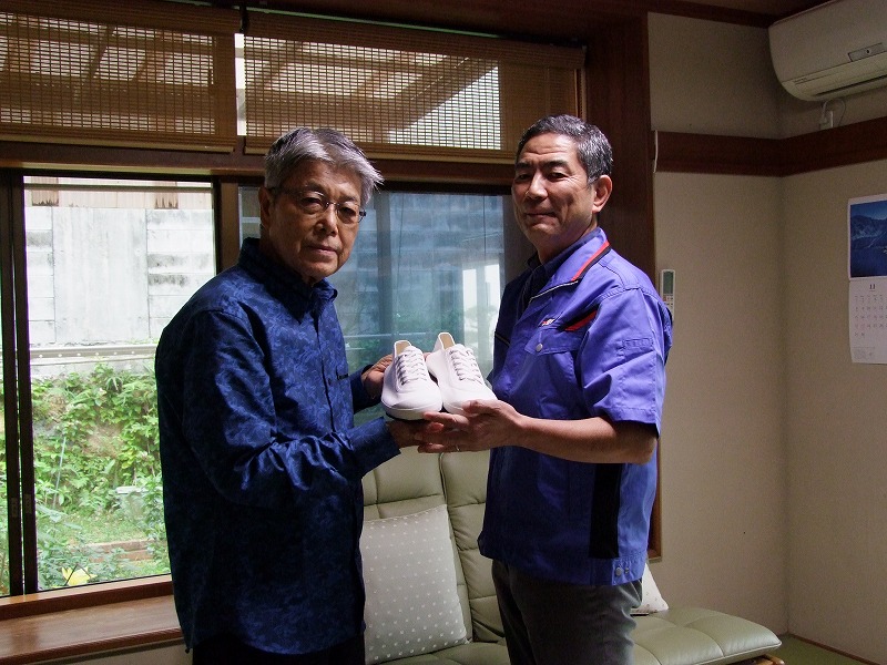 当時、届かなかった64年東京五輪聖火ランナーシューズの復刻版をプレゼントされた来夏の東京五輪沖縄県聖火ランナーも務める宮城勇さん（左）