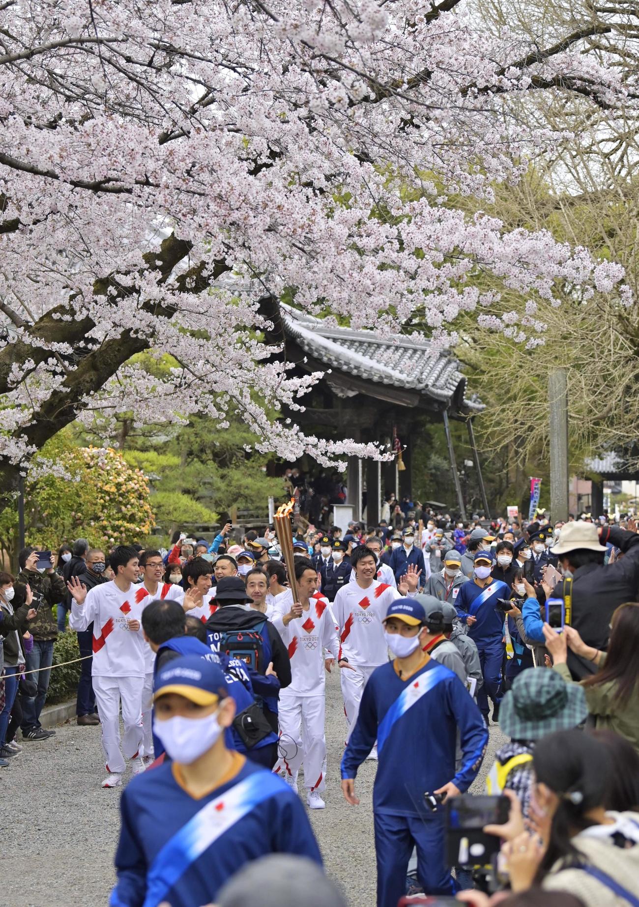 本堂が国宝に指定されている鑁阿寺（ばんなじ）の境内を走る聖火ランナー（共同）
