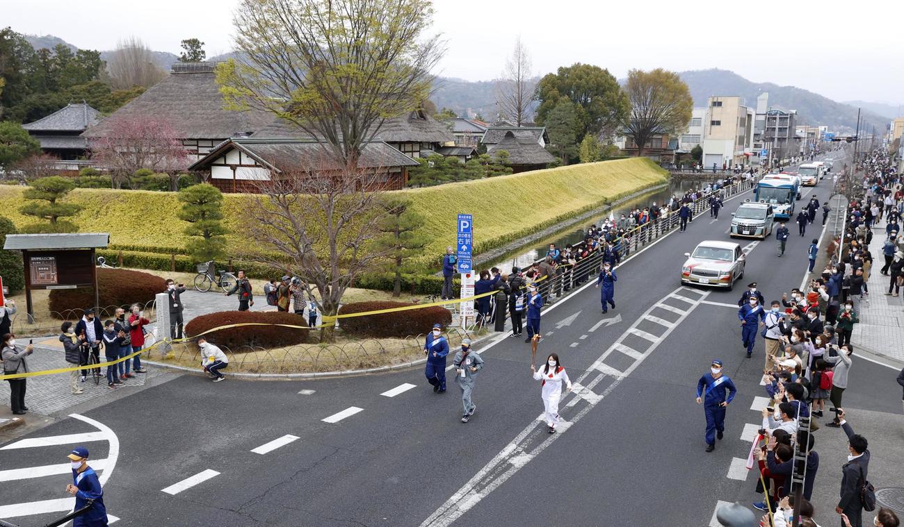 現存する日本最古の学校とされる足利学校の前を走る聖火ランナー（共同）