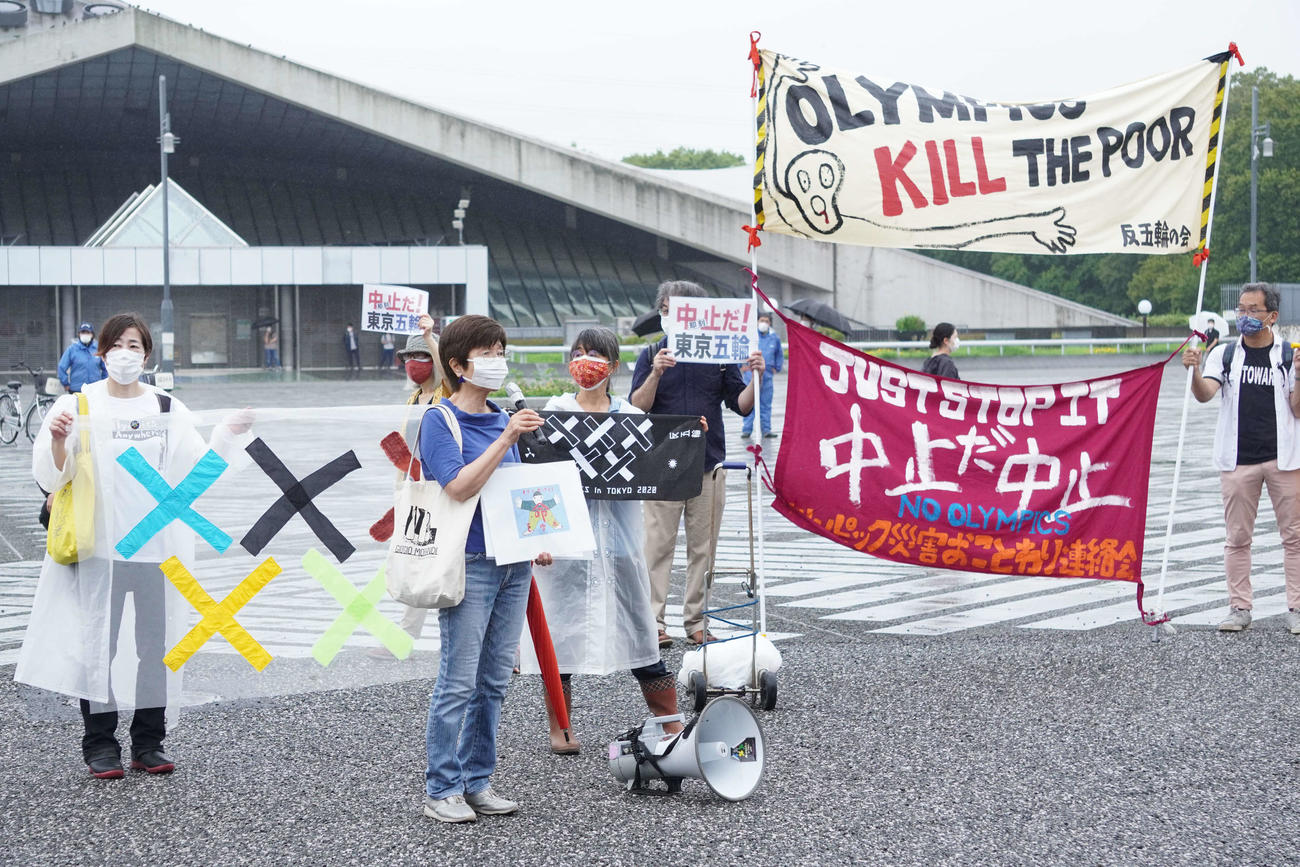 聖火お披露目式の会場前で五輪反対運動を行う市民団体