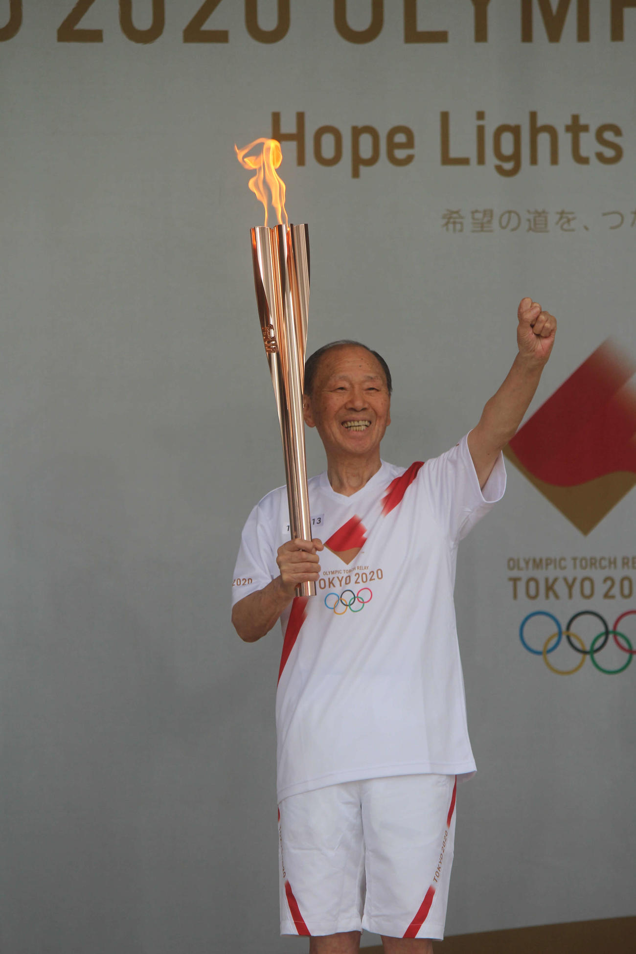 トーチを掲げて笑顔の小野さん