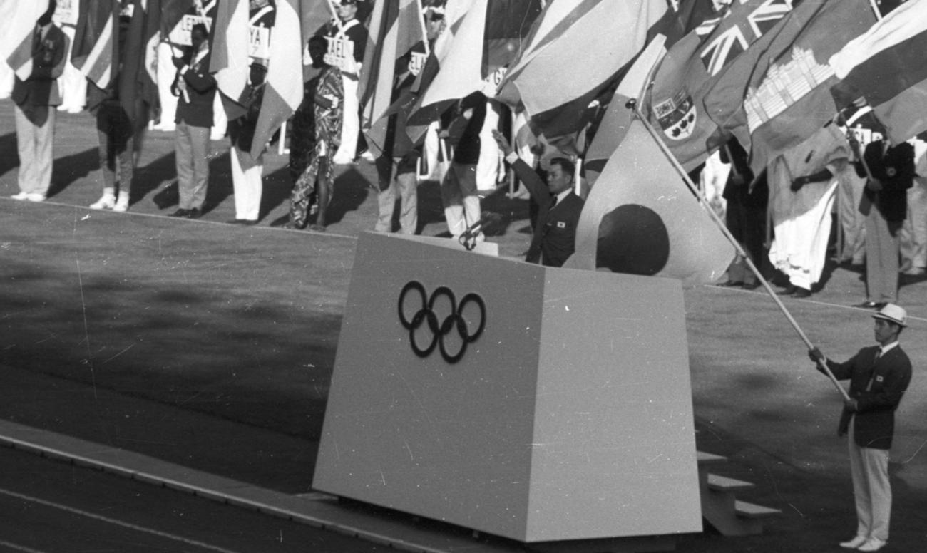 64年10月、東京五輪で選手宣誓をする日本選手団主将の小野喬。右は旗手の福井誠