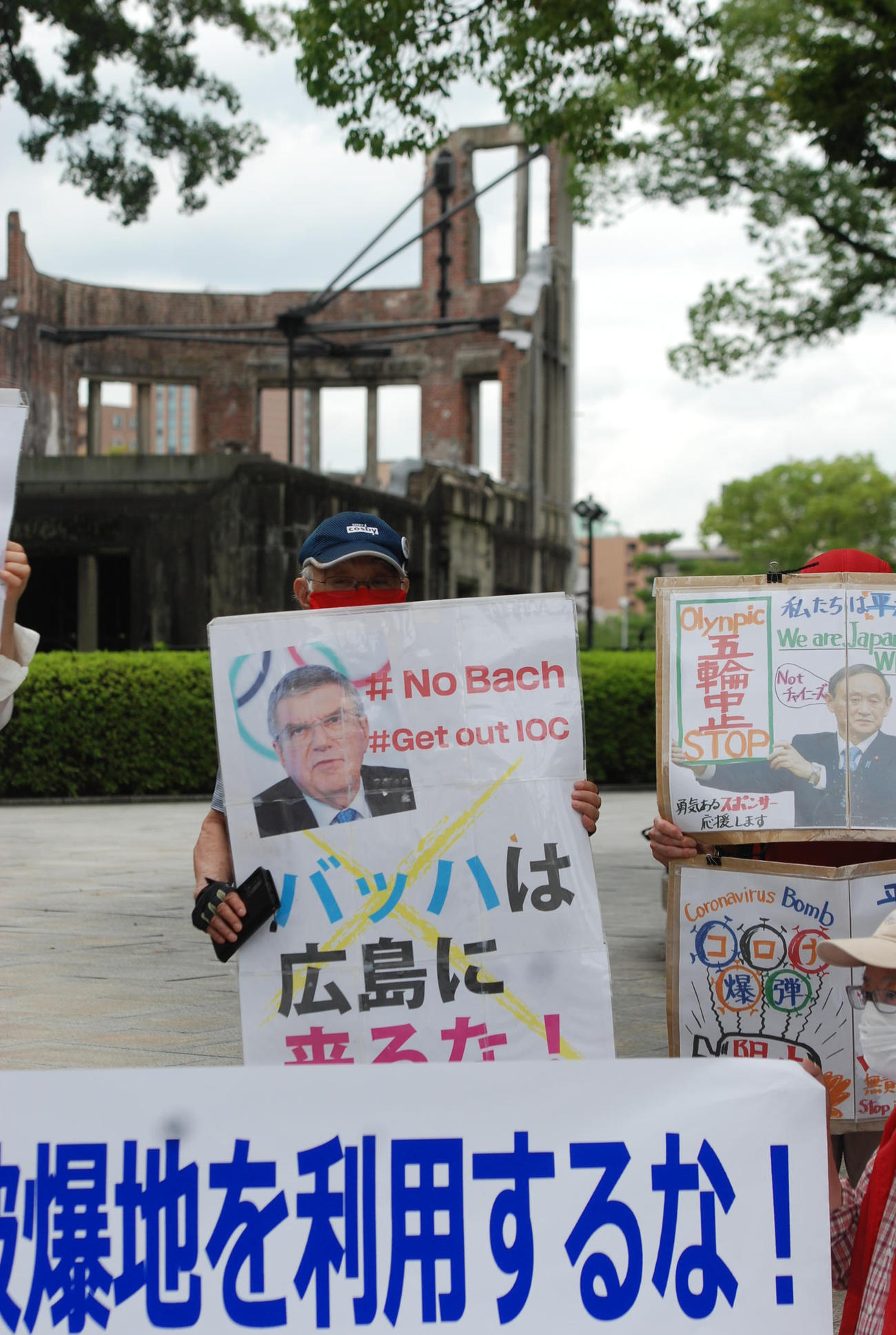 原爆ドーム前で「バッハは広島に来るな！」とプラカードを掲げる市民団体（撮影・松浦隆司）