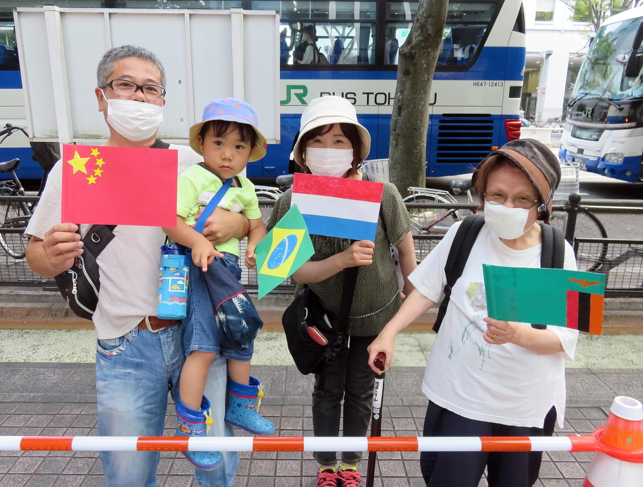 出場各国の手作り国旗を持って仙台駅から宮城スタジアムにシャトルバスで出発する3世代家族（撮影・鎌田直秀）