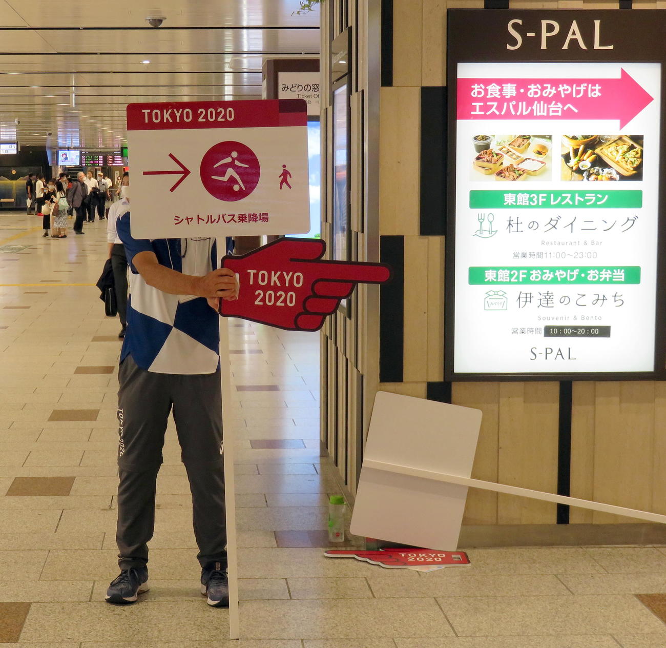 仙台駅の新幹線改札出口でシャトルバス乗降場を案内するボランティアスタッフ（撮影・鎌田直秀）