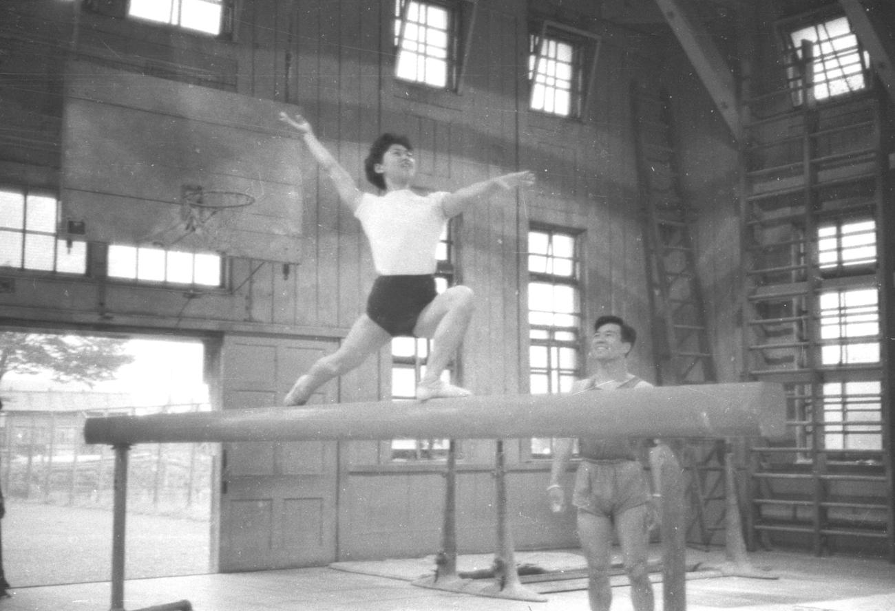 59年7月、夫の喬さんが見守る中、平均台の練習をする小野清子さん