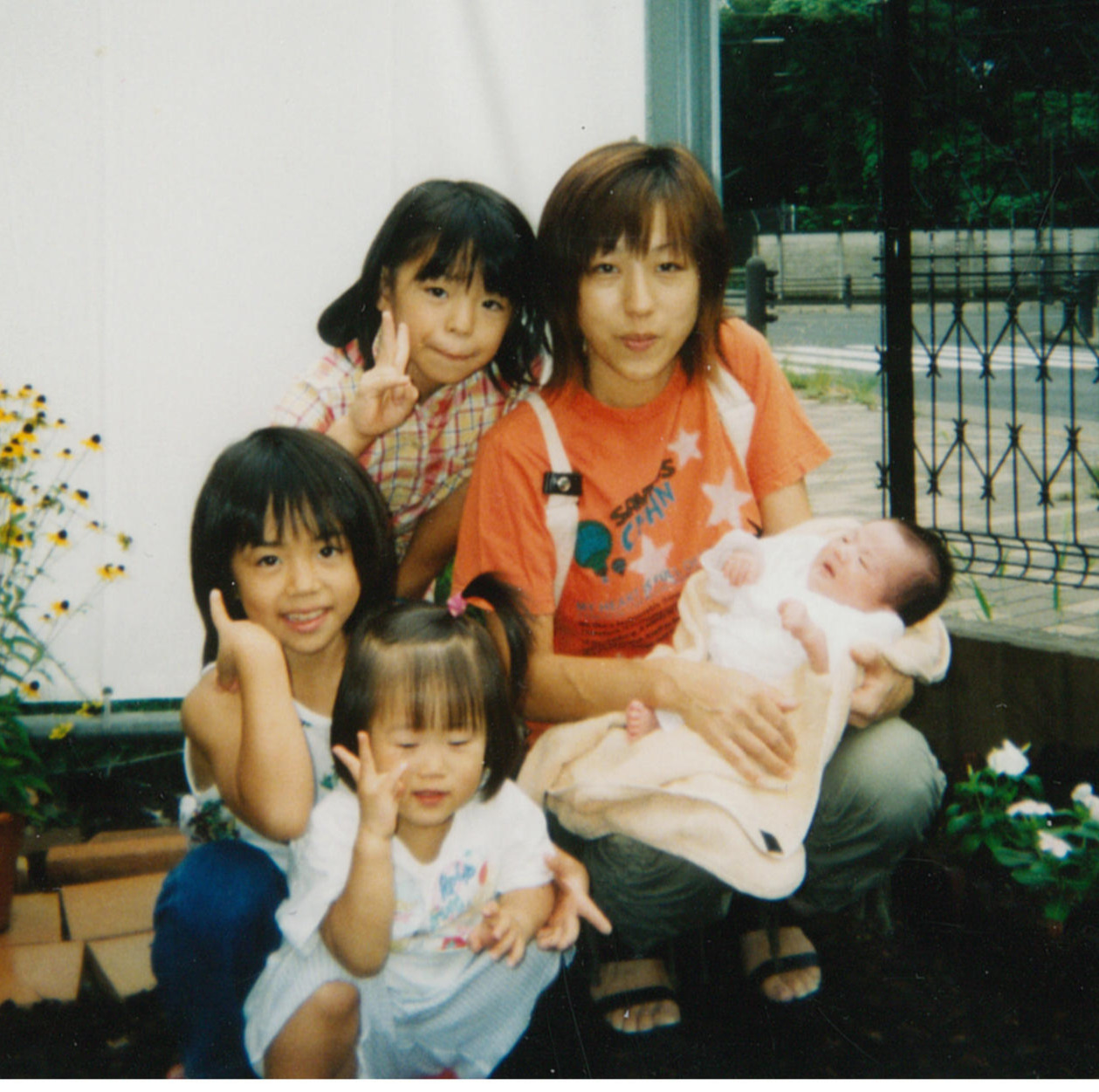 幼少期の村上（左）。母英子さん、きょうだいと