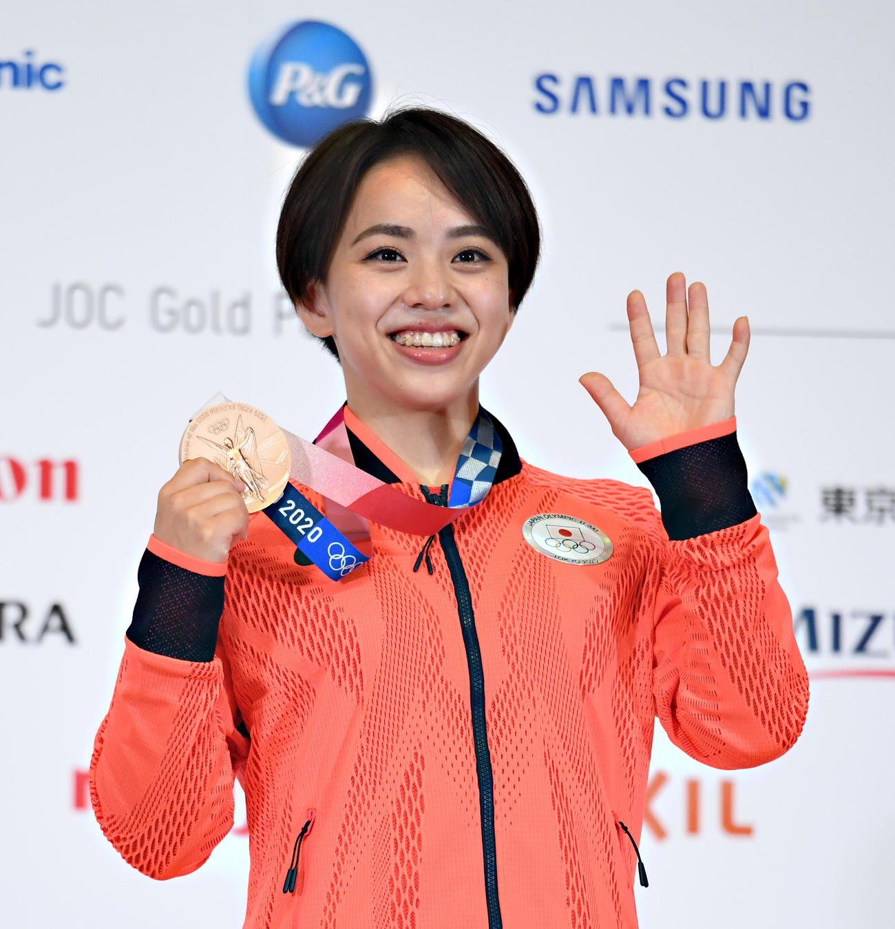 体操女子種目別床運動で銅メダルを獲得した村上は、会見でメダルを手に笑顔で撮影に応じる（代表撮影）