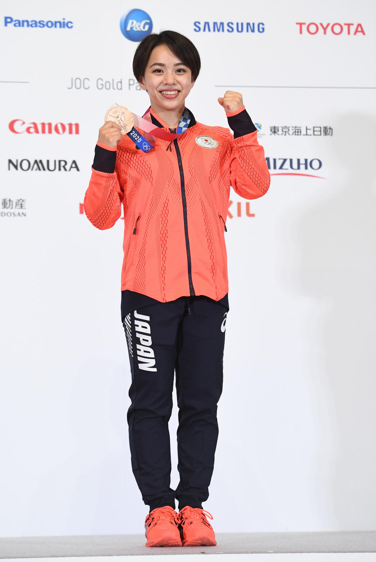体操女子種目別床運動で銅メダルを獲得した村上は、会見でメダルを手に笑顔で撮影に応じる（代表撮影）