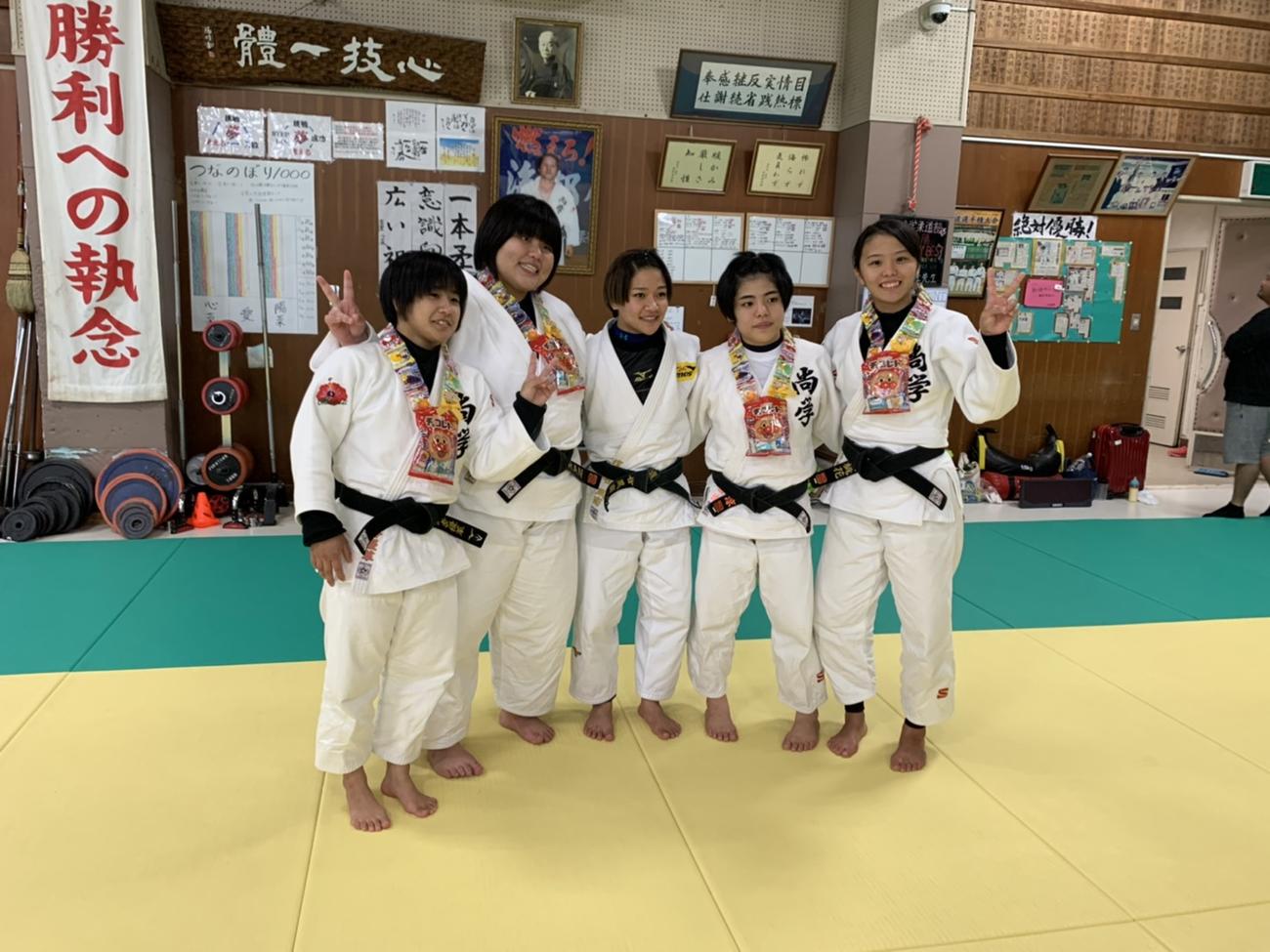 沖縄尚学の卒業生にお菓子の首飾りをプレゼントした渡名喜風南（中央）