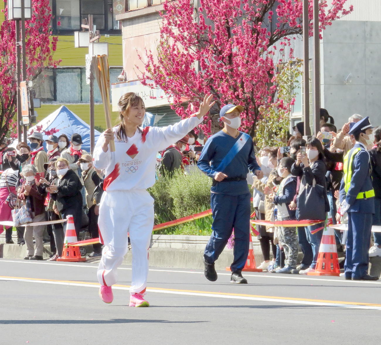 笑顔で手を振りながら聖火ランナーを務める阪神タイガースwomen三浦伊織外野手（撮影・鎌田直秀）