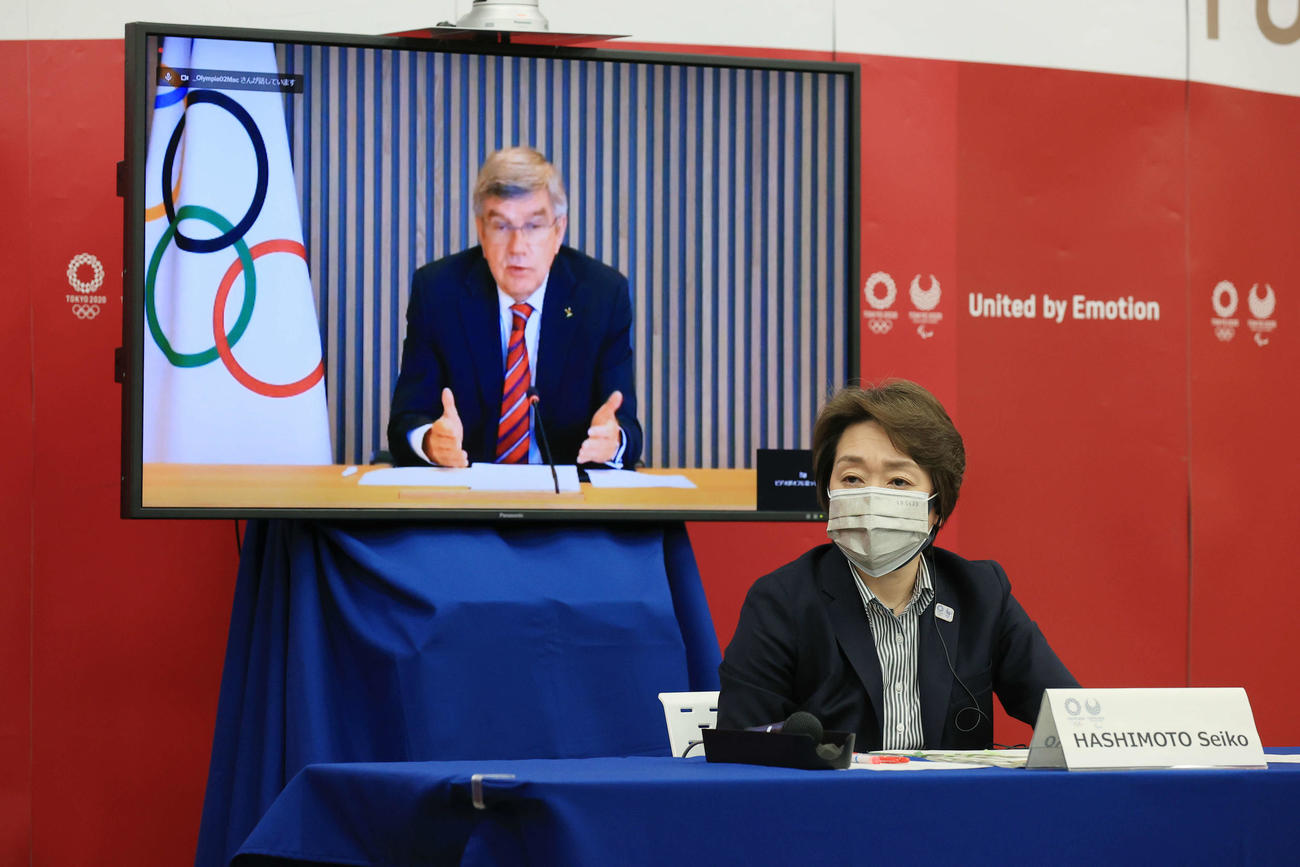 東京五輪・パラリンピックに向けた5者協議で国際オリンピック委員会（IOC）のトーマス・バッハ会長（後方モニター）の発言を聞く大会組織委員会の橋本聖子会長（代表撮影）