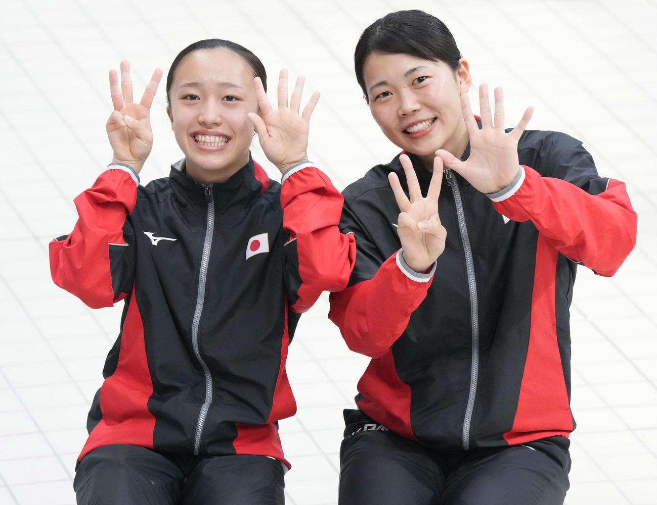 女子シンクロ板飛び込み決勝で8位となり、指で8を作る榎本（右）と宮本（撮影・鈴木みどり）