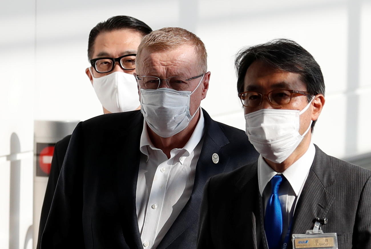 羽田空港に到着したIOCのコーツ調整委員長（中央＝ロイター）