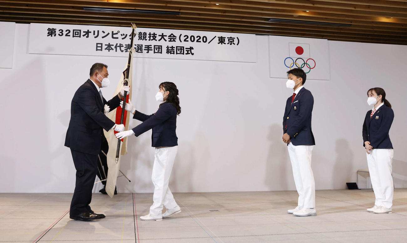 日本代表選手団結団式でJOCの山下会長（左端）から団旗を受け取る旗手の須崎。左3人目から主将の山県、副主将の石川（代表撮影）
