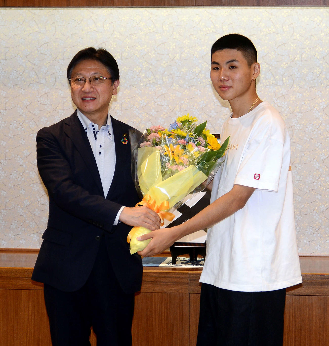 田辺市長（左）から花束を受け取り、笑顔を見せる青木