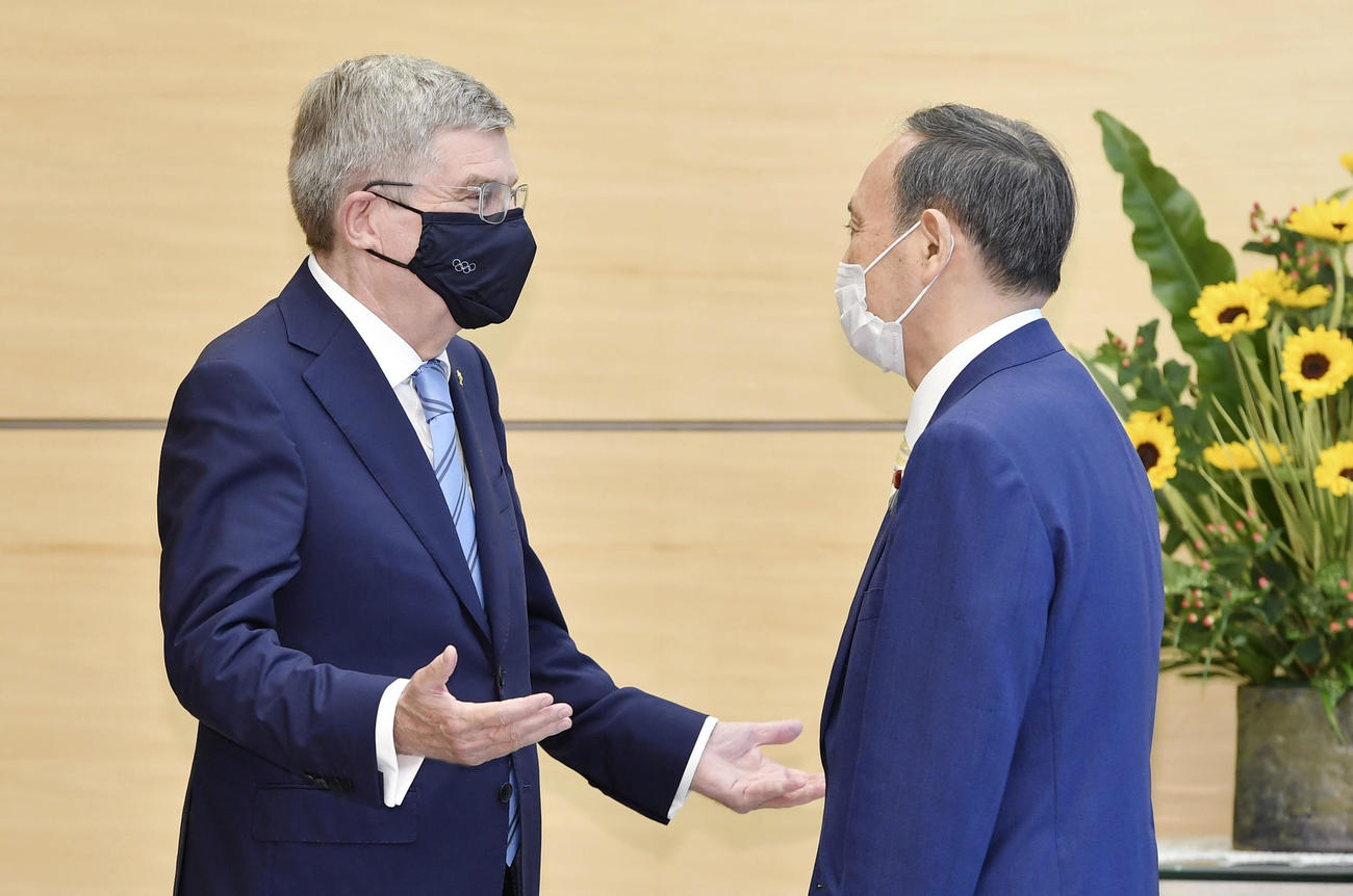 会談に臨むIOCのバッハ会長（左）と菅首相（共同）
