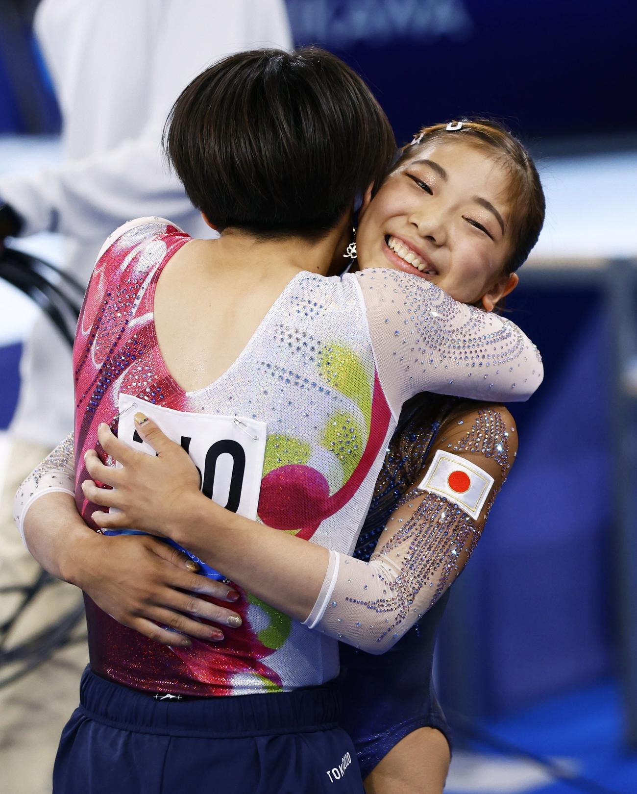 体操女子予選　平均台の演技を終え村上茉愛（手前）と抱き合う芦川うらら（共同）