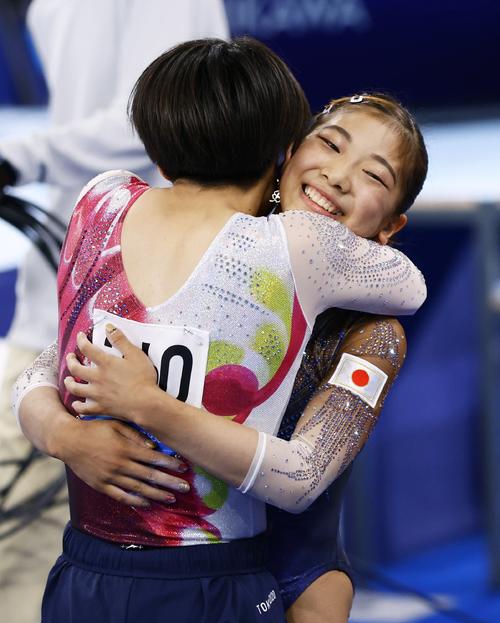 体操女子予選　平均台の演技を終え村上茉愛（手前）と抱き合う芦川うらら（共同）