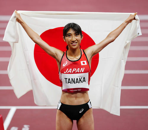 女子1500メートルで8位入賞し、日の丸を背に広げる田中（撮影・江口和貴）