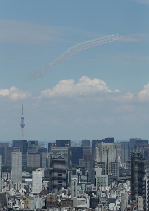 東京スカイツリーの上空をカラースモークを出しながら飛行するブルーインパルス（渋谷スカイから・撮影・足立雅史）
