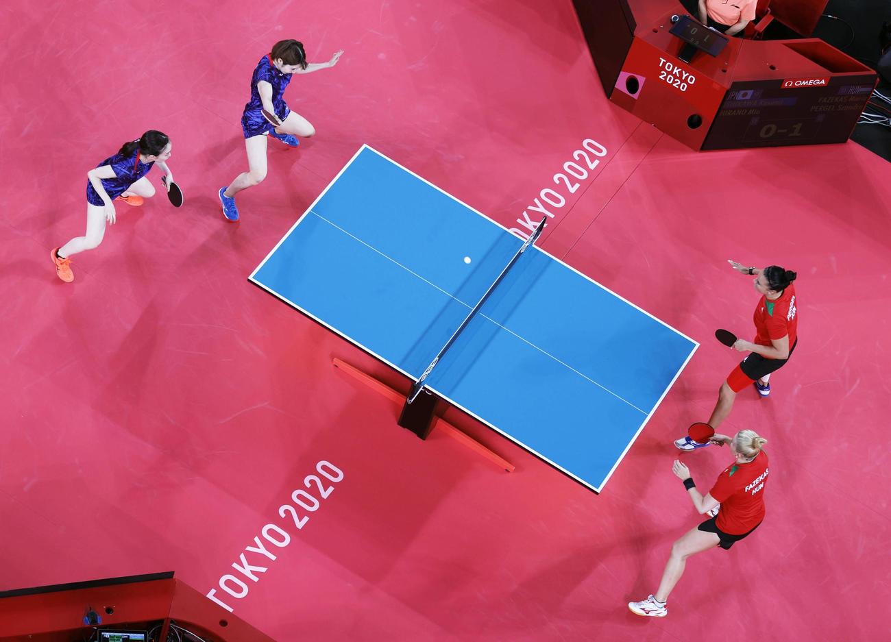 女子団体1回戦　ハンガリー戦の第1試合でプレーする石川佳純（上左）、平野美宇組（共同）