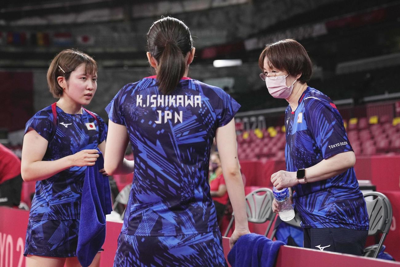 女子団体1回戦　ハンガリー戦の第1試合で、相手のタイムアウトの間に石川佳純（中央）、平野美宇（左）組と話す女子代表の馬場監督（共同）