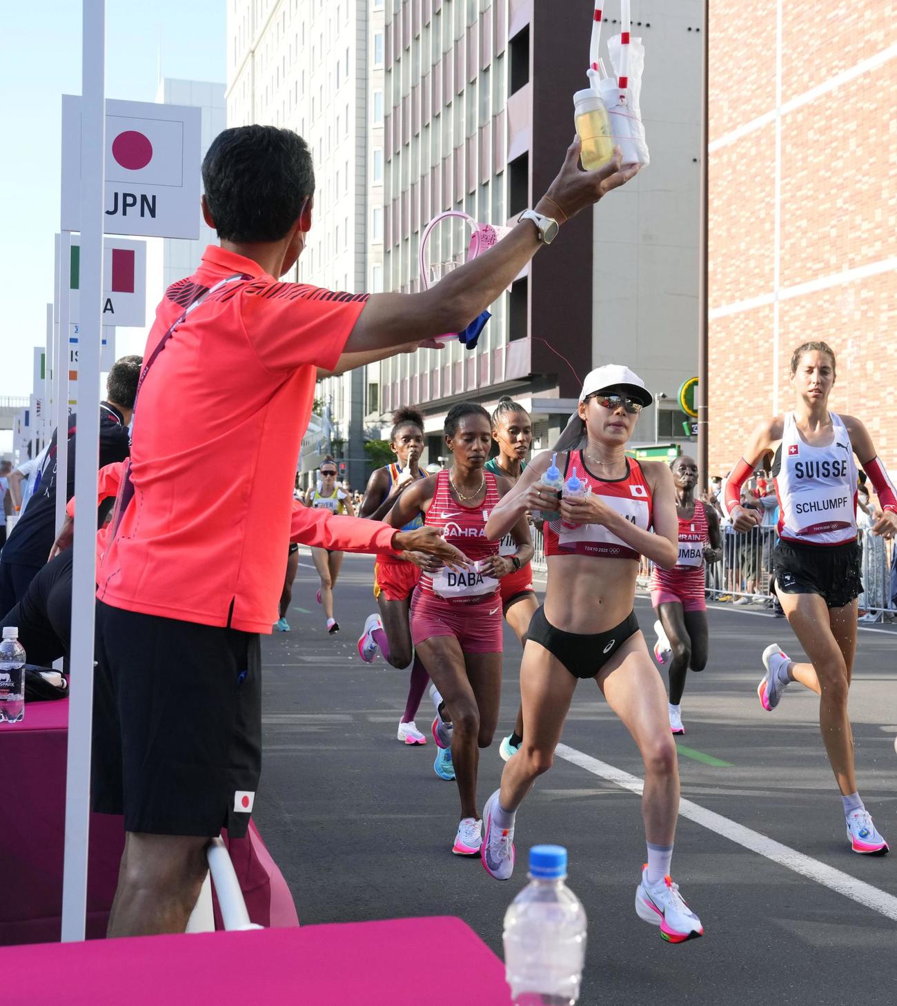 13キロ付近の給水所で、ドリンクを取る一山麻緒（右手前）（共同）