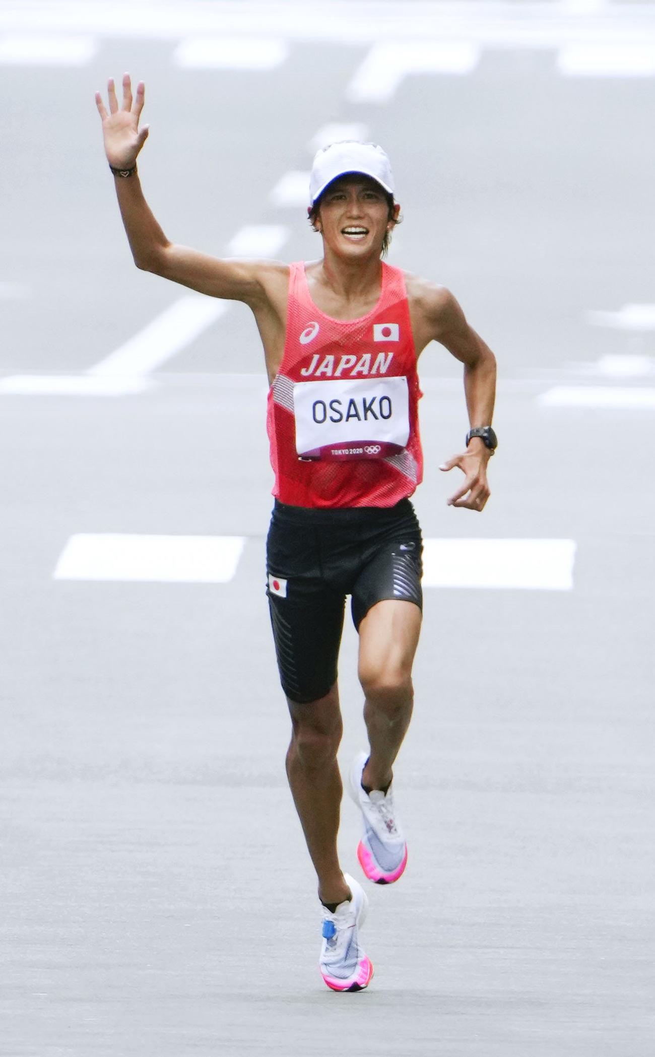 歓声に応えながらゴールに向かう大迫傑。6位入賞を果たした（共同）
