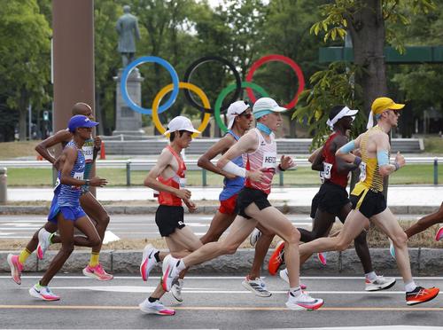 レース序盤、五輪マークのモニュメント前を力走する中村匠吾（中央左）（共同）