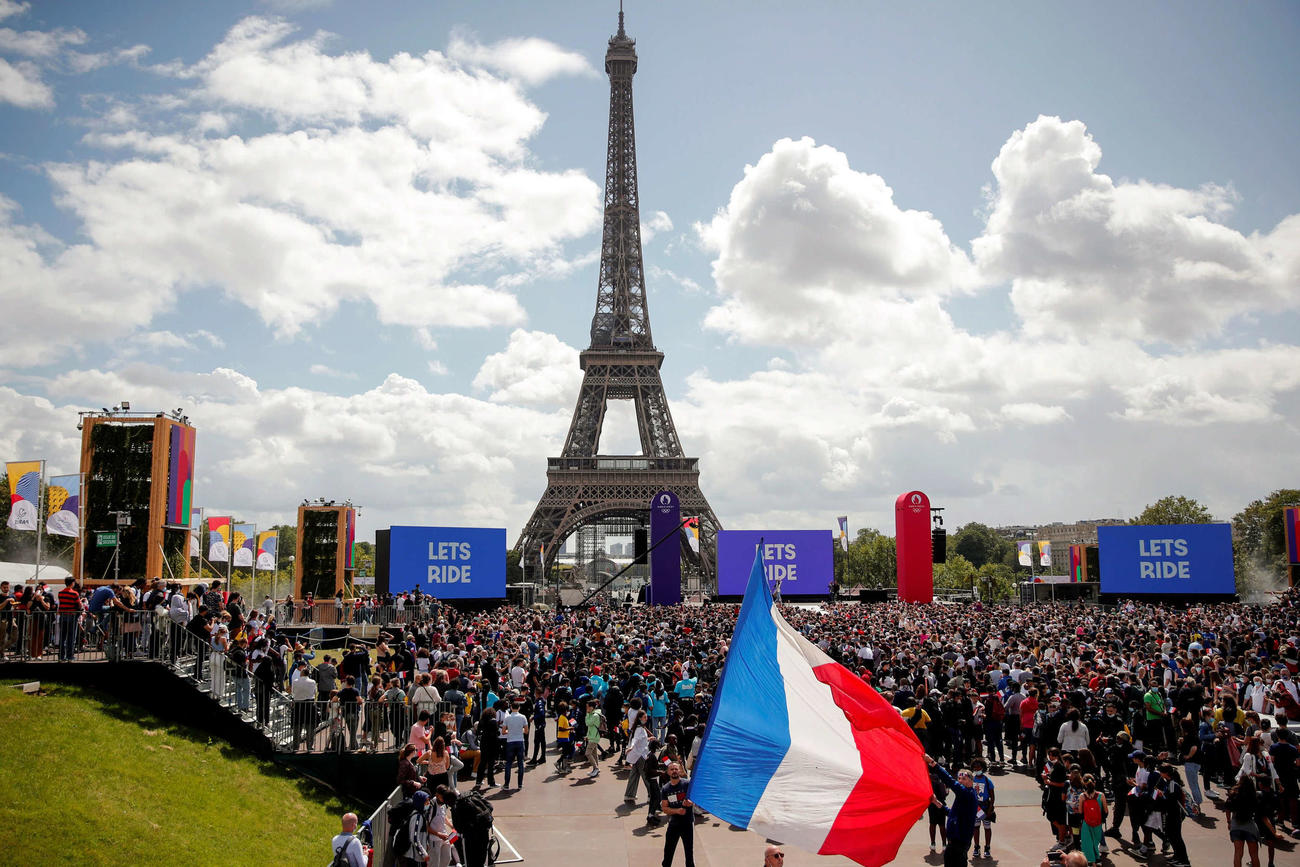 次回五輪開催地のパリで、エッフェル塔の前に大勢の人たちが集まって東京五輪の閉会式を見る（ロイター）