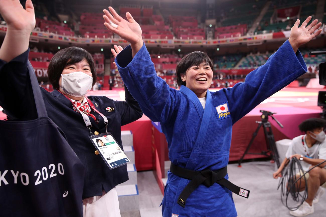 柔道女子78キロ級決勝　金メダルを獲得し、塚田コーチ（左）といっしょに笑顔で手を振る浜田（撮影・パオロ　ヌッチ）